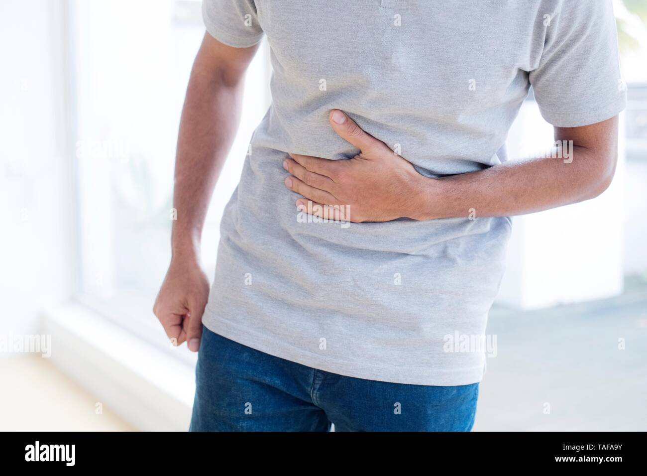 Man touching his stomach in pain Stock Photo
