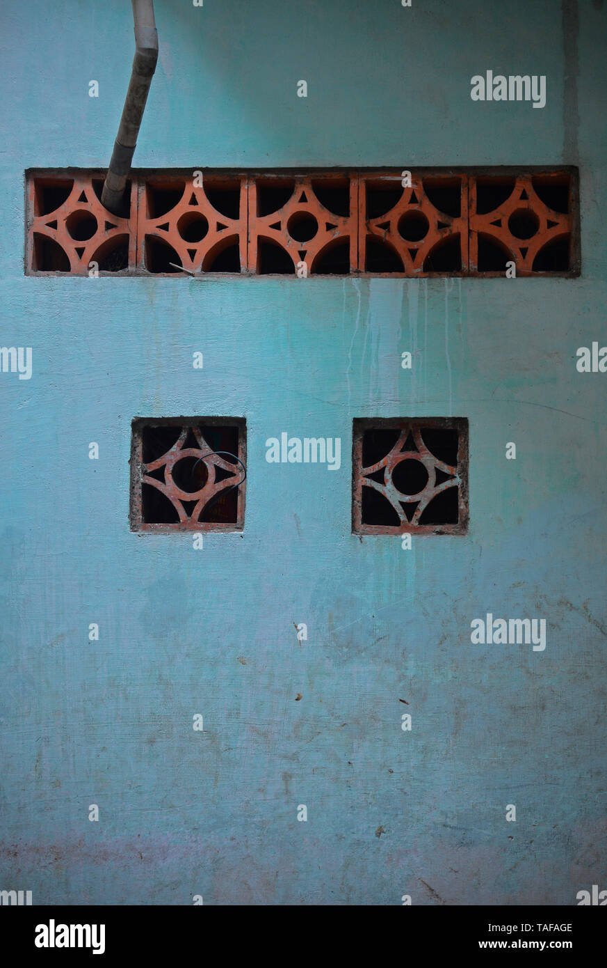 Small ventilation windows in a blue wall near Tran Hung Dao in District 1, Saigon, Vietnam Stock Photo