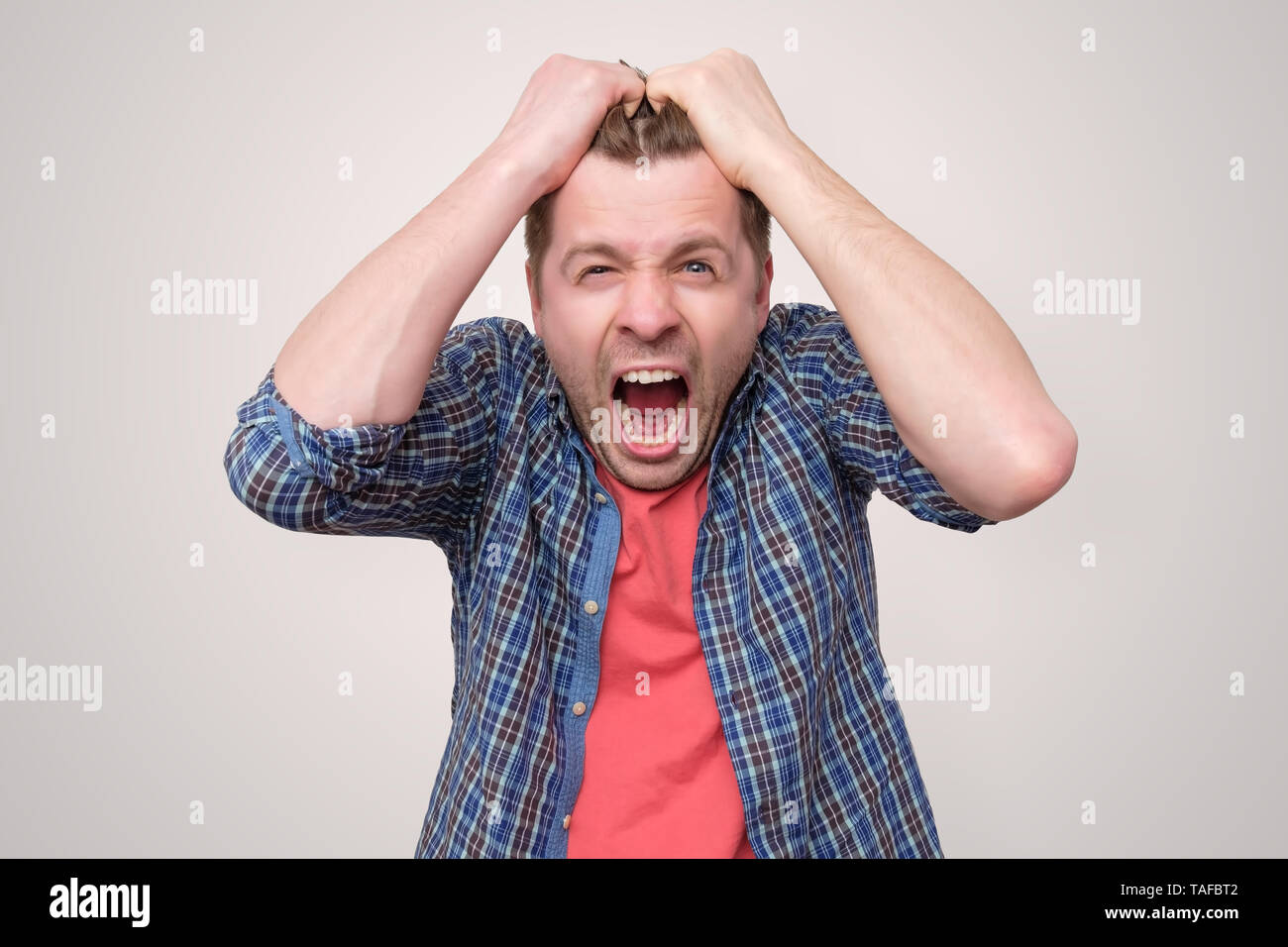 Furious, enraged man with mouth opened in shout Stock Photo