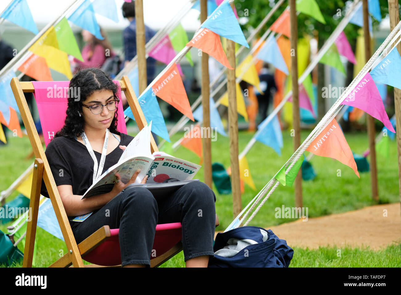 Hay Festival, Hay on Wye, Powys, Wales, UK - Friday 24th May 2019 - A visitor enjoys a rest between events and sessions to look at a book on the Festival lawns on the second day of this years Hay Festival - the Hay Festival continues to Sunday 2nd June. Photo Steven May / Alamy Live News Stock Photo