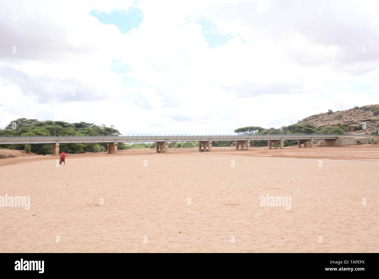 Kenya. 23rd May, 2019. A man is seen crossing the dried up Merille River, a seasonal river and one of the major rivers on the Great North Road also known as the Cape to Cairo Road.The road runs through the arid parts of the Northern Kenya connecting with Ethiopia. Its tarmacking was fully completed recently and it's expected to open up the region's economic potential. Credit: Allan Muturi/SOPA Images/ZUMA Wire/Alamy Live News Stock Photo