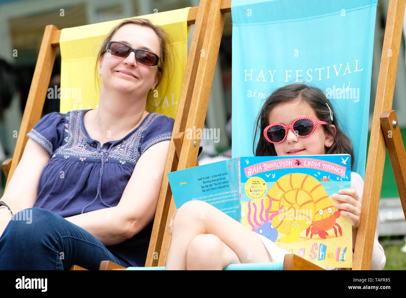 Hay Festival, Hay on Wye, Powys, Wales, UK - Saturday 25th May 2019 - A young visitors enjoys her new Julia Donaldson picture book on the Festival lawns between events and speakers on Day 3 of this years Festival. Photo Steven May / Alamy Live News Stock Photo