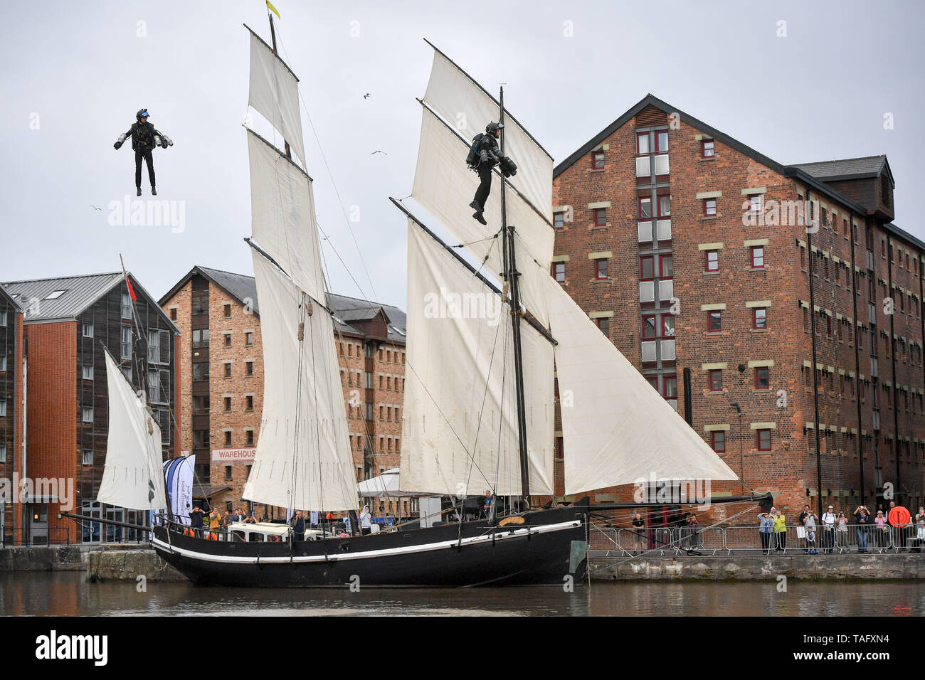 Gravity Industries Jet Suit pilots fly over the water at Gloucester's Tall Ships Festival during a rehearsal for a three Gravity Jet suit pilot simultaneous flight. Stock Photo
