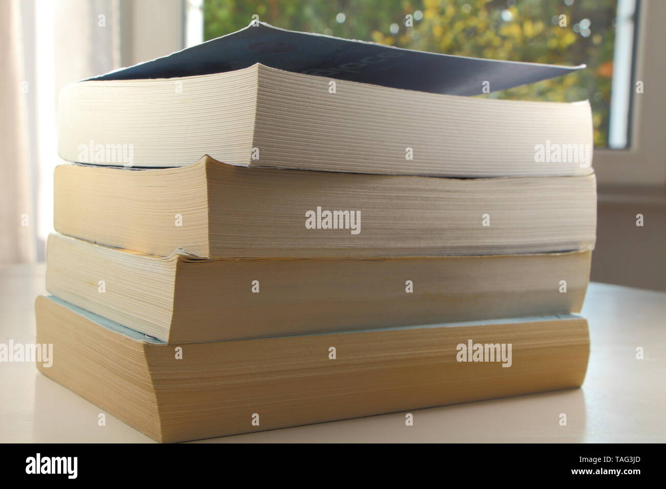 Pile of four paperbacks on a table Stock Photo