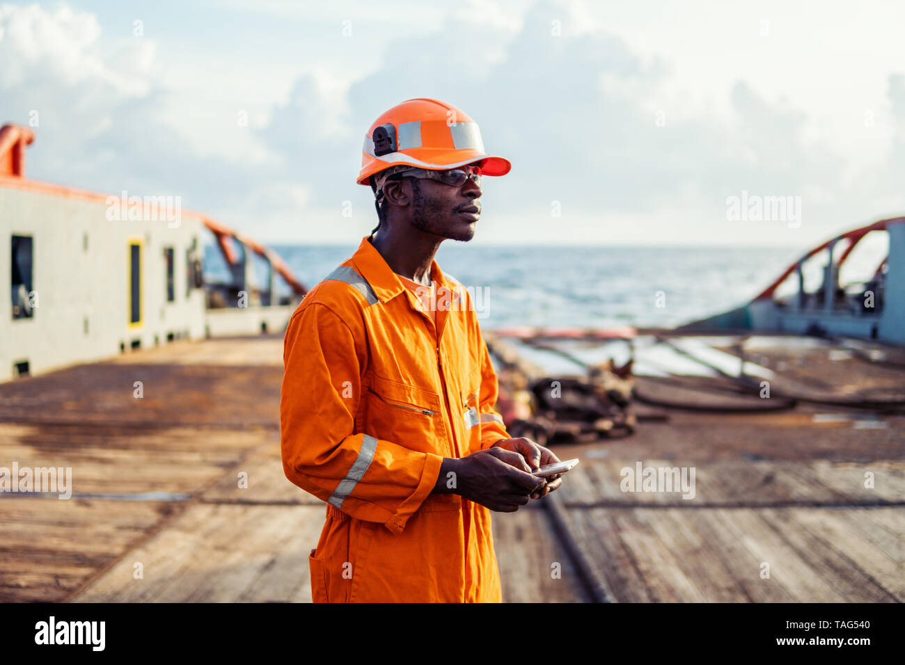 Tired Seaman AB or Bosun on deck of vessel or ship Stock Photo