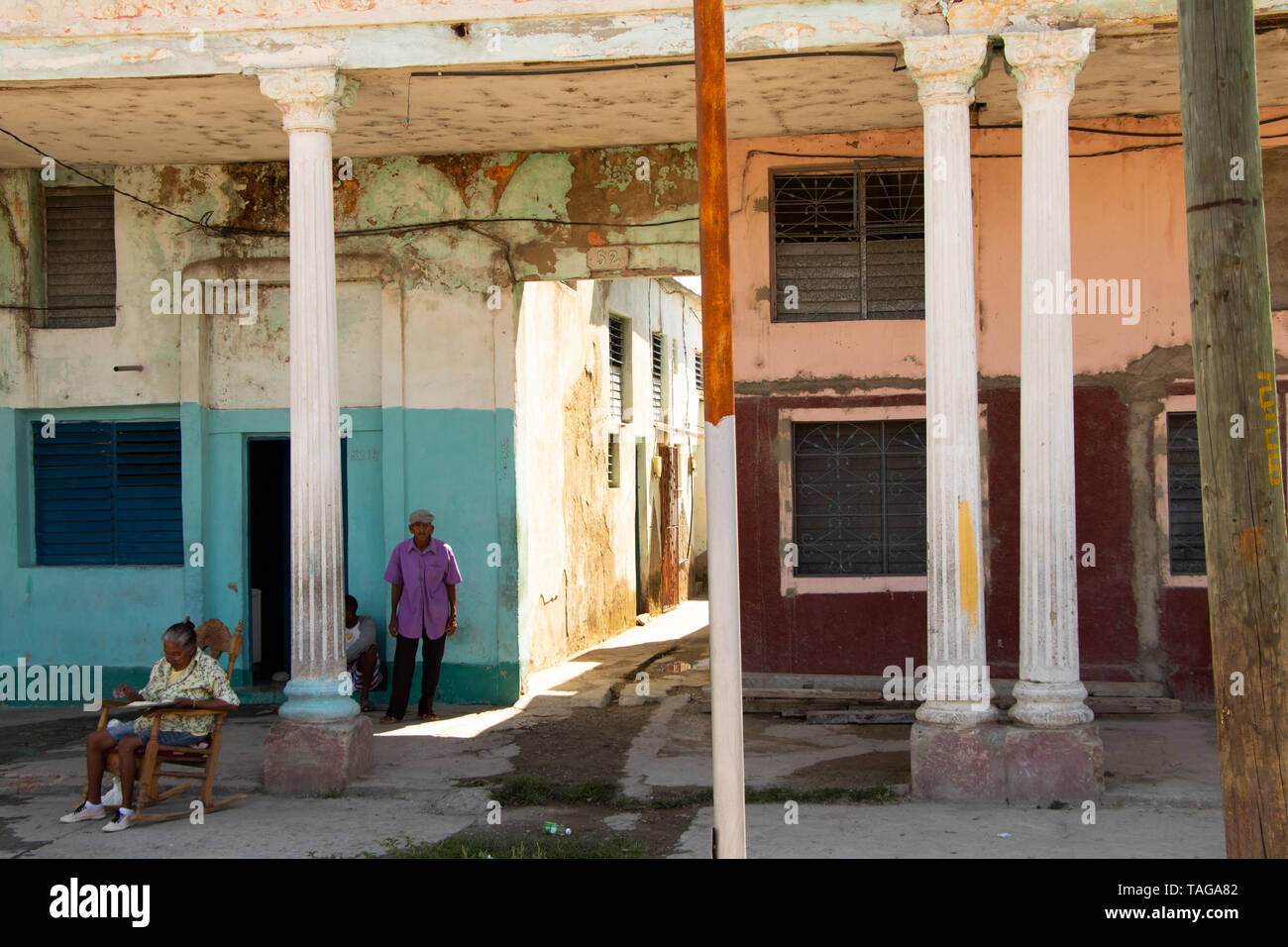 26/04/2019 Cienfuegos, Cuba, Street scene with senior adults standing and sitting by the street in Cienfuegos Stock Photo