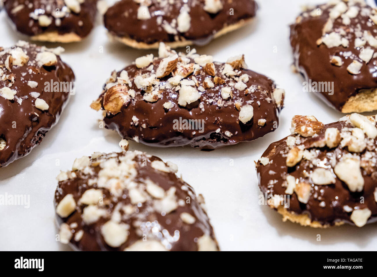 French Madeleines Dipped in Milk Chocolate with Crushed Hazelnuts Sprinkled on Top, Sitting on a