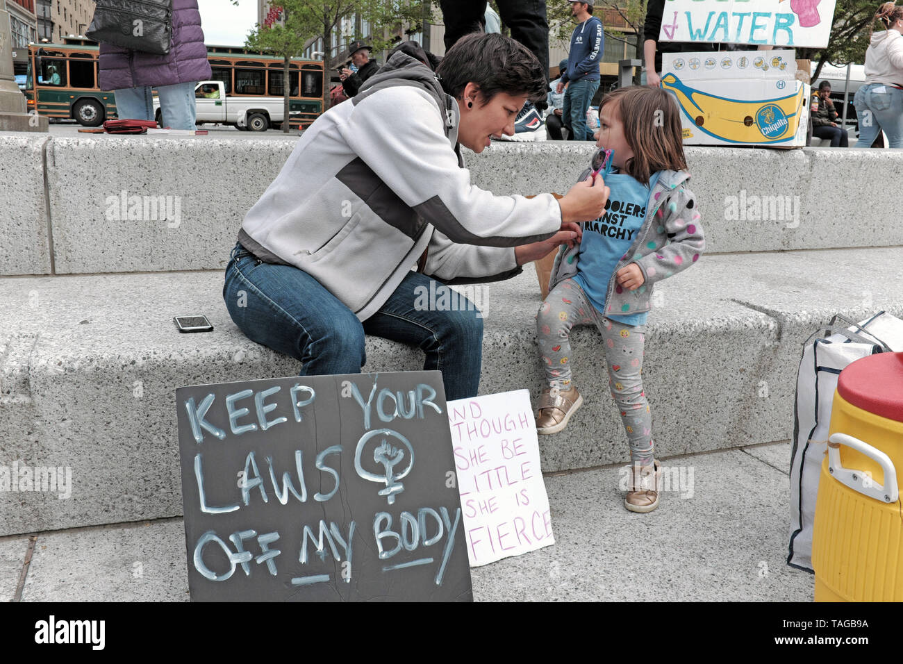 Woman and young girl take a rest in Cleveland's Public Square at the May 2019 Pro-Choice Rally against changes to Ohio abortion laws. Stock Photo