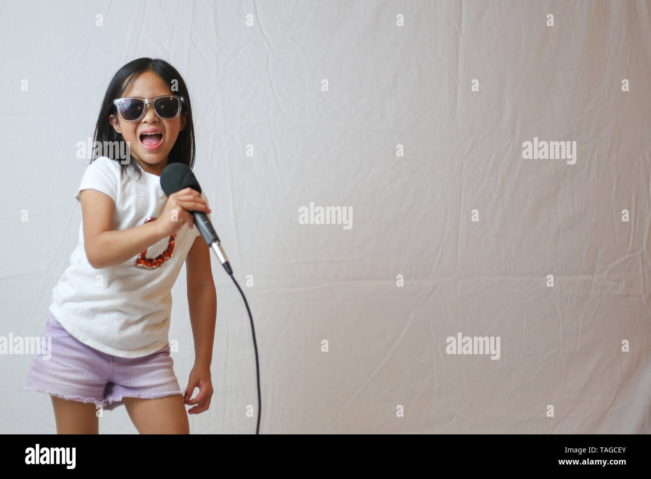 Little Asian girl playing rock star Stock Photo