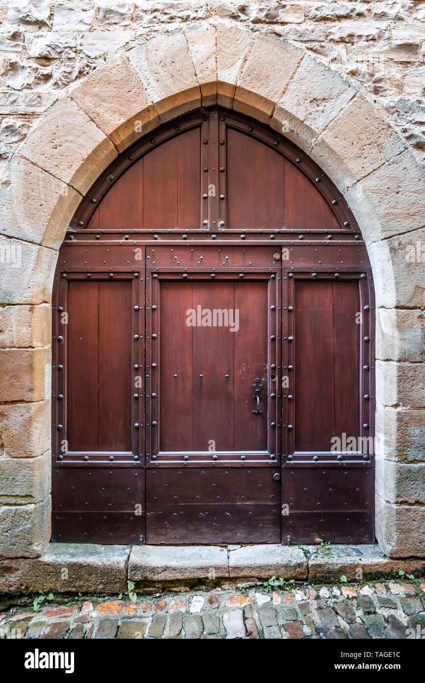 Medieval brown door and pointed stone arch of Gothic architecture Stock Photo