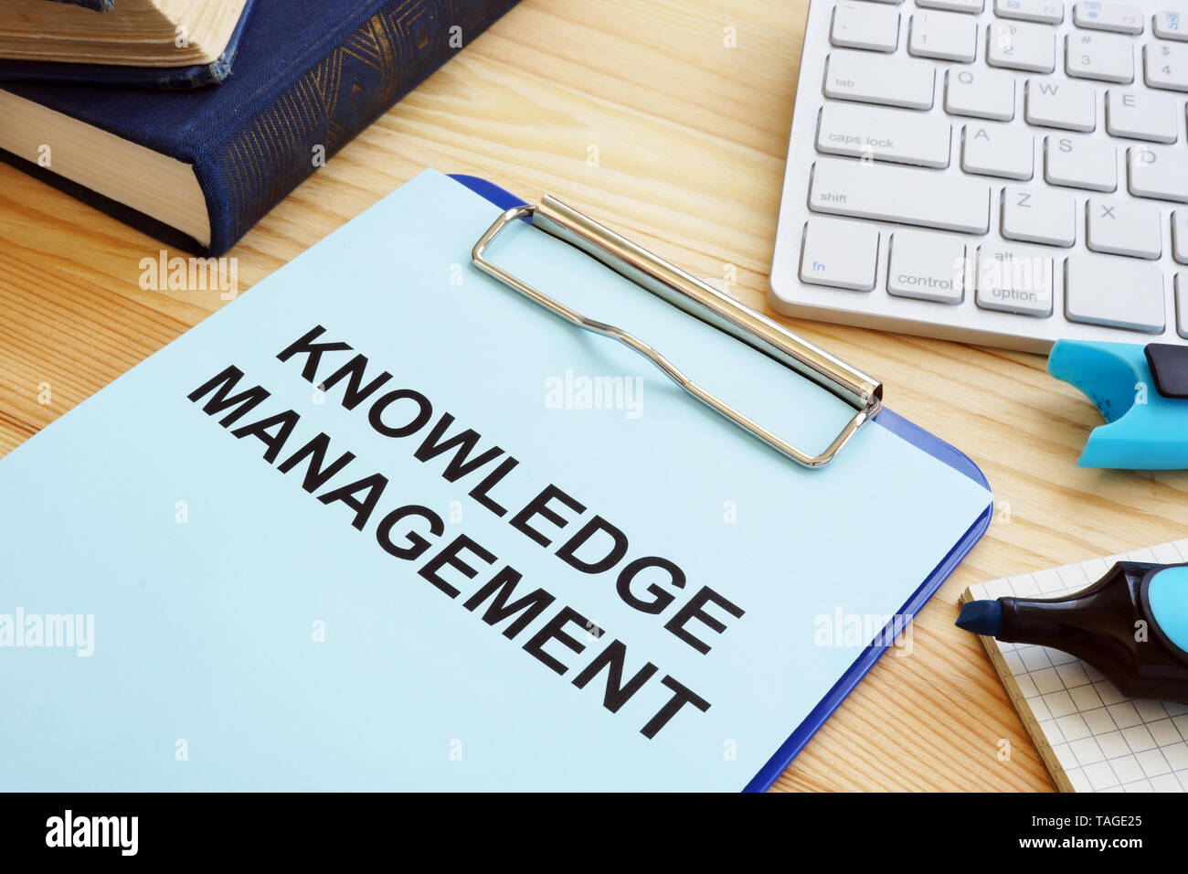 Knowledge management concept. Clipboard and books on table. Stock Photo