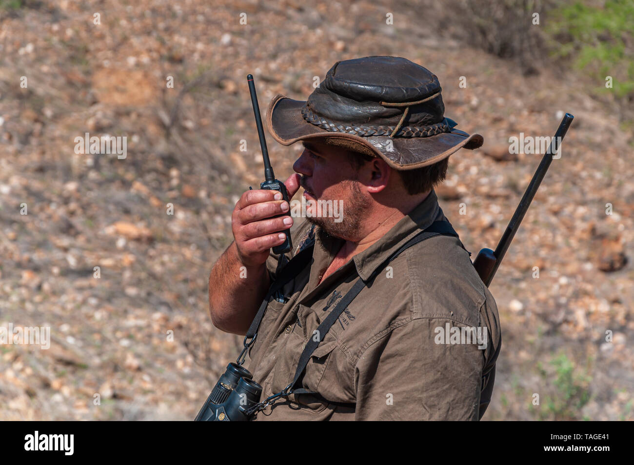 A professional hunter communicating via two-way radio. Stock Photo