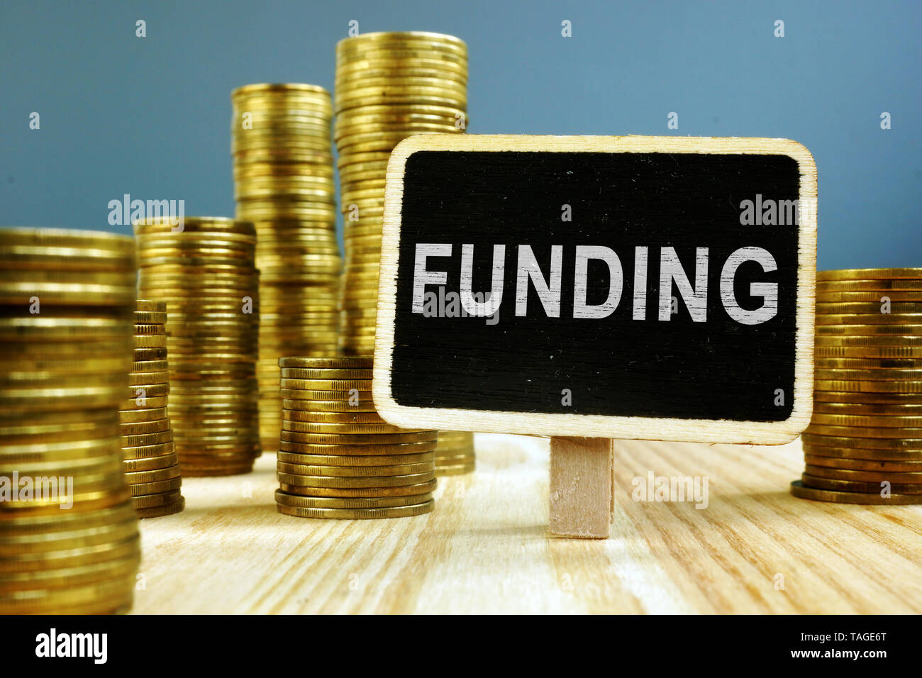 Funding concept. Coins stack on wooden surface. Stock Photo