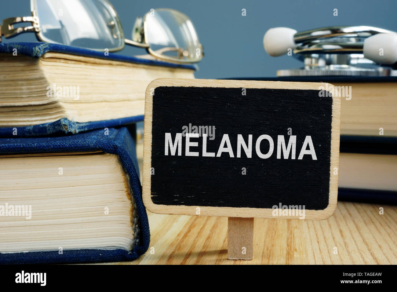 Melanoma disease concept. Books and glasses on desk. Stock Photo