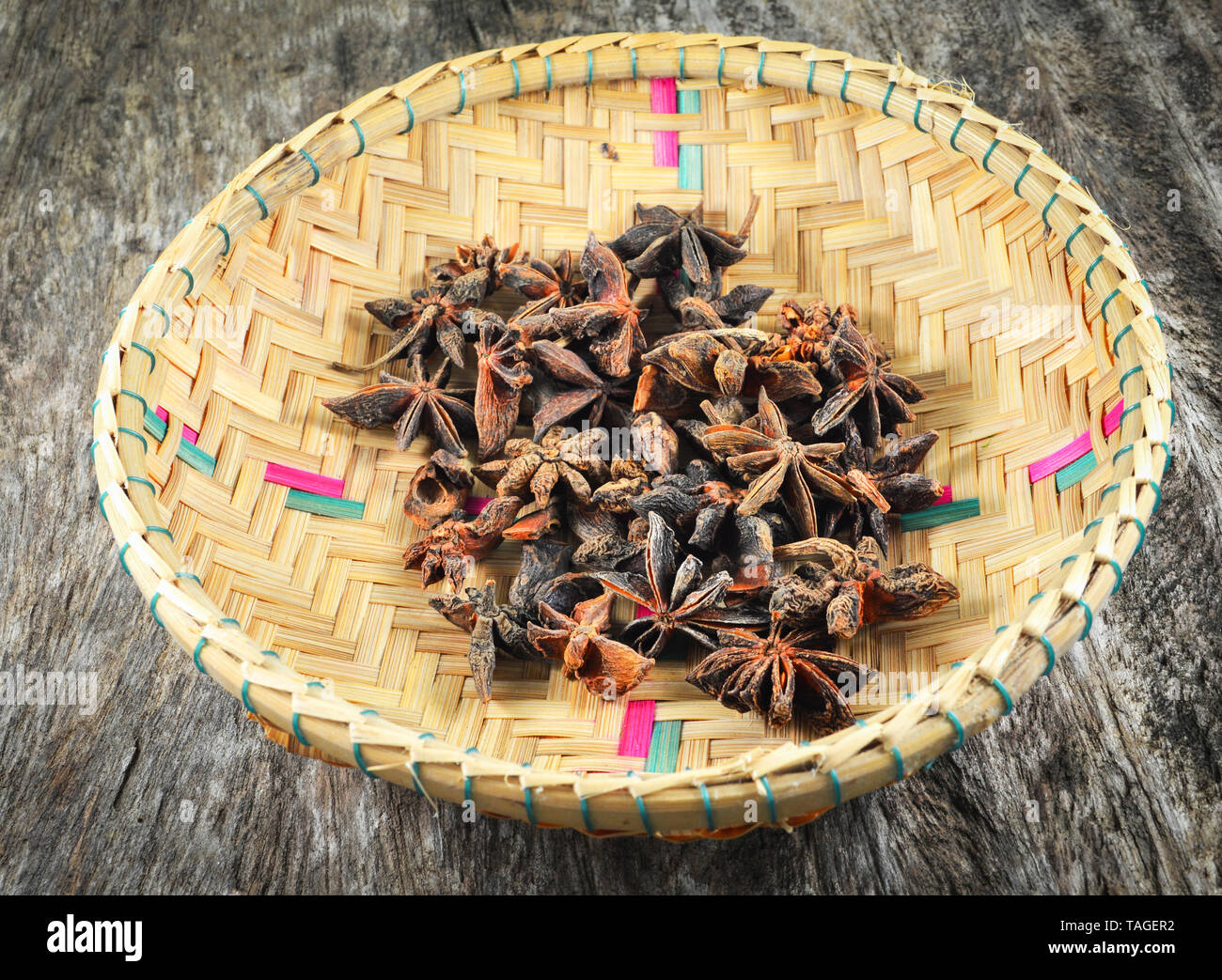 Chinese star anise spice fruit on bamboo basket on old wood background