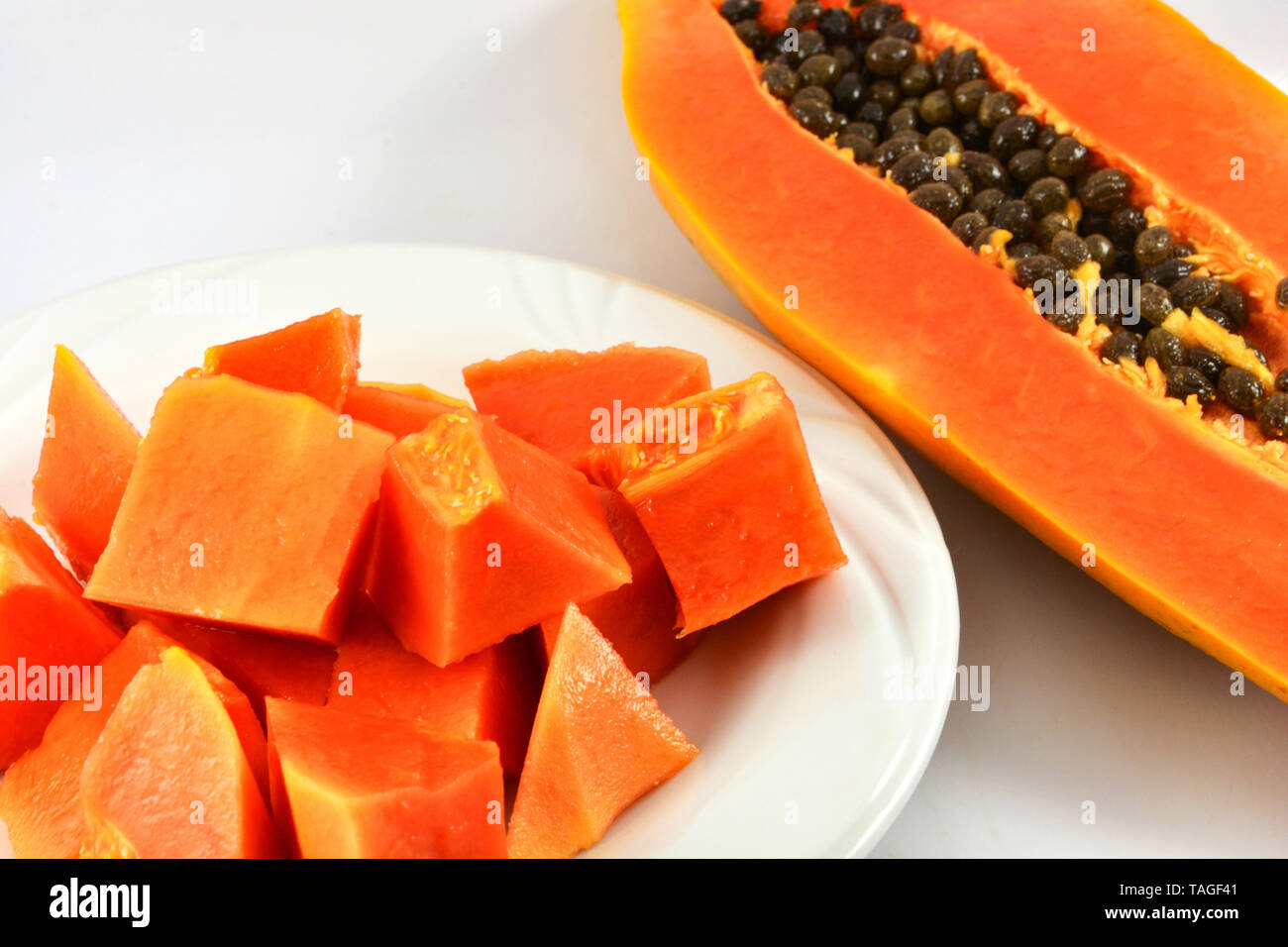 papaya slice on plate and ripe papaya fruit cut half dissect on white