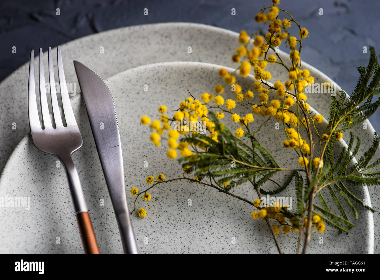 Festive table setting with mimosa flowers for easter holiday dinner Stock Photo