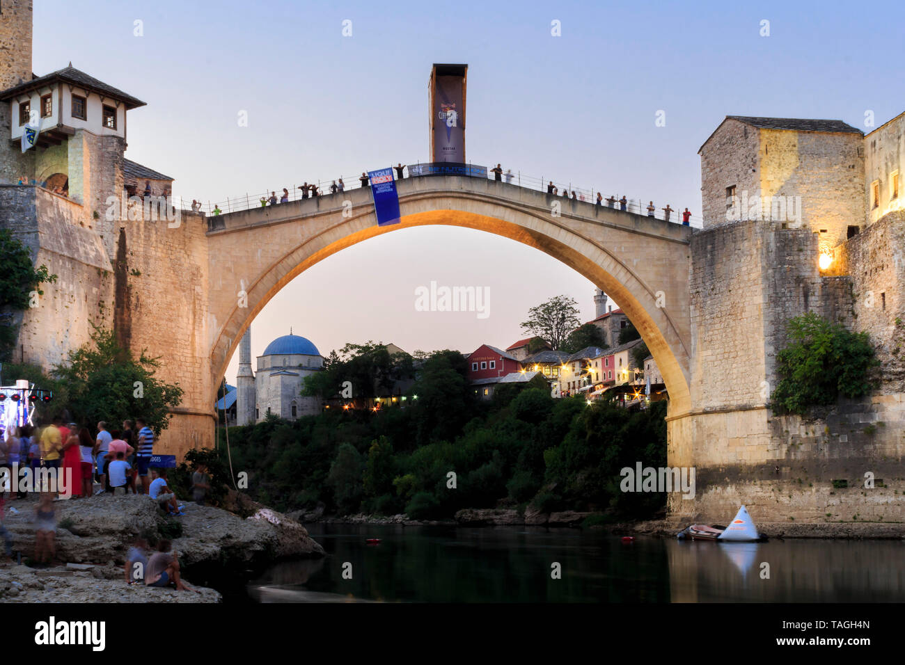 MOSTAR, BOSNIA AND HERZEGOVINA - AUGUST 13, 2015: Dusk photo of Tourist and locals walking near Old bridge in Mostar while there are preparation for R Stock Photo