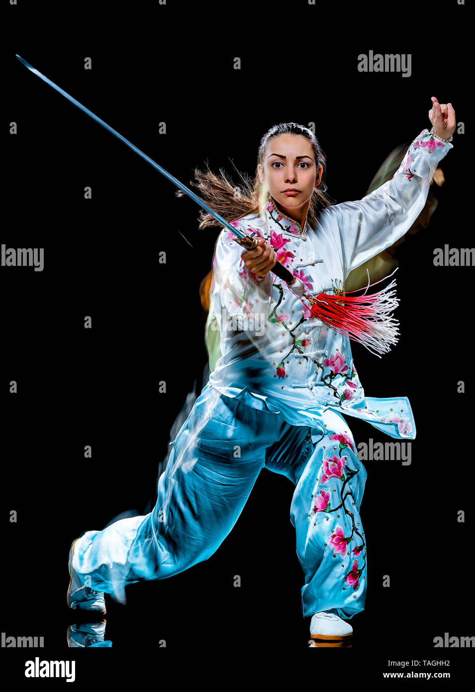 one chinese woman partacticing  Tai Chi Chuan Tadjiquan posture studio shot isolated on black background  with light painting effect Stock Photo