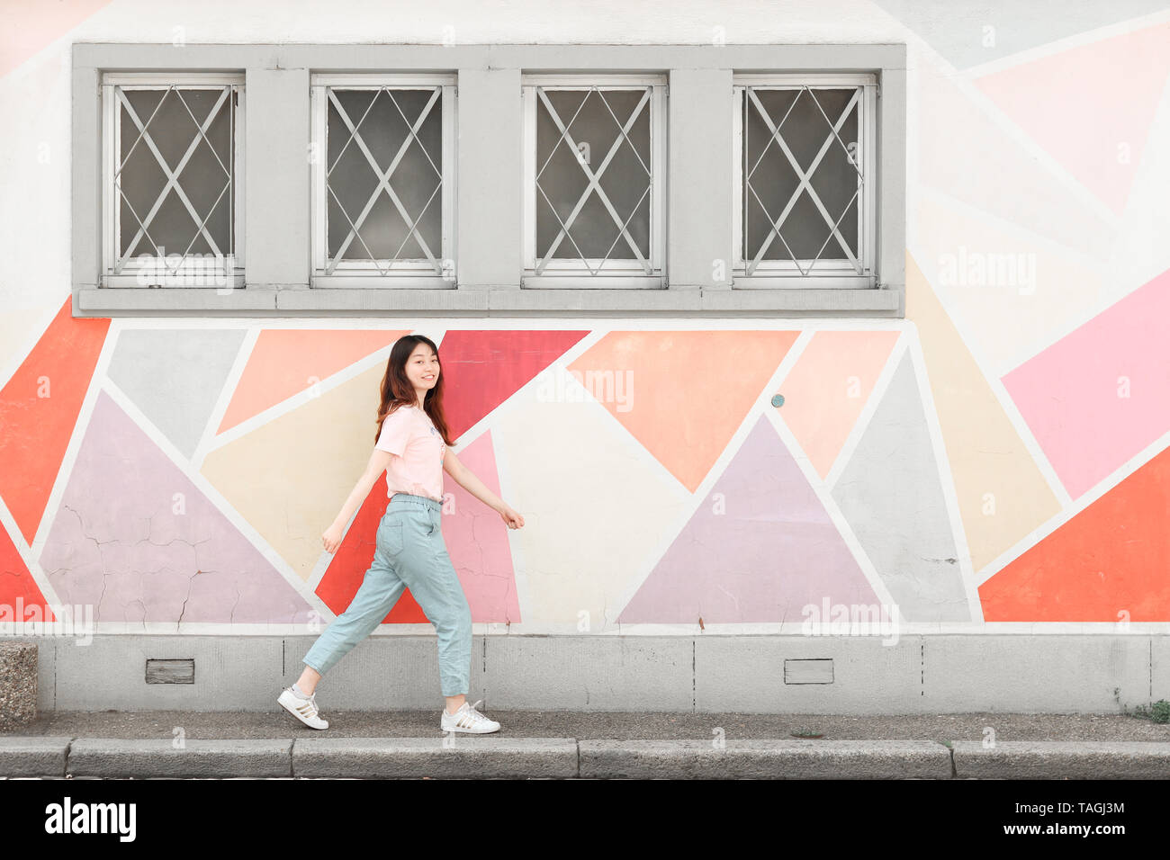 Young Asian Student / Model and Colorful Wall in Strasbourg, France, Europe Stock Photo