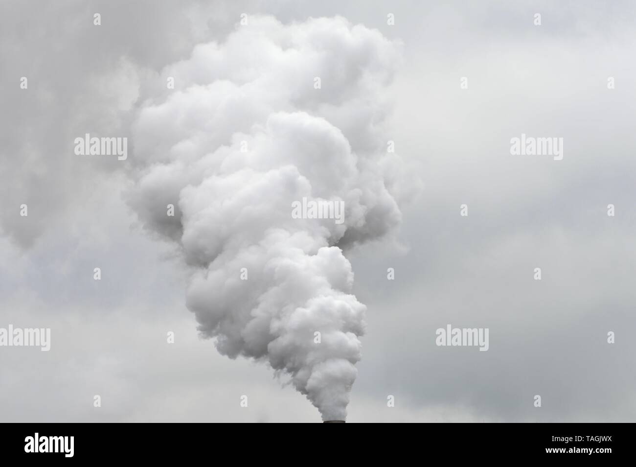impressing cloud of smoke joining the rain clouds in the sky Stock Photo