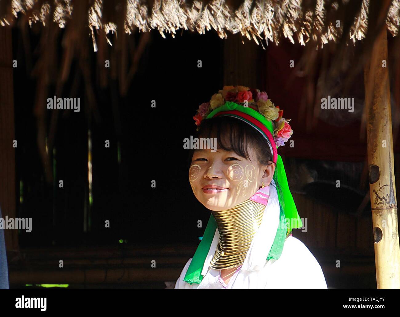LONGNECK KAREN VILLAGE, THAILAND - DECEMBER 17. 2017: Long neck woman sitting in front of a hut Stock Photo