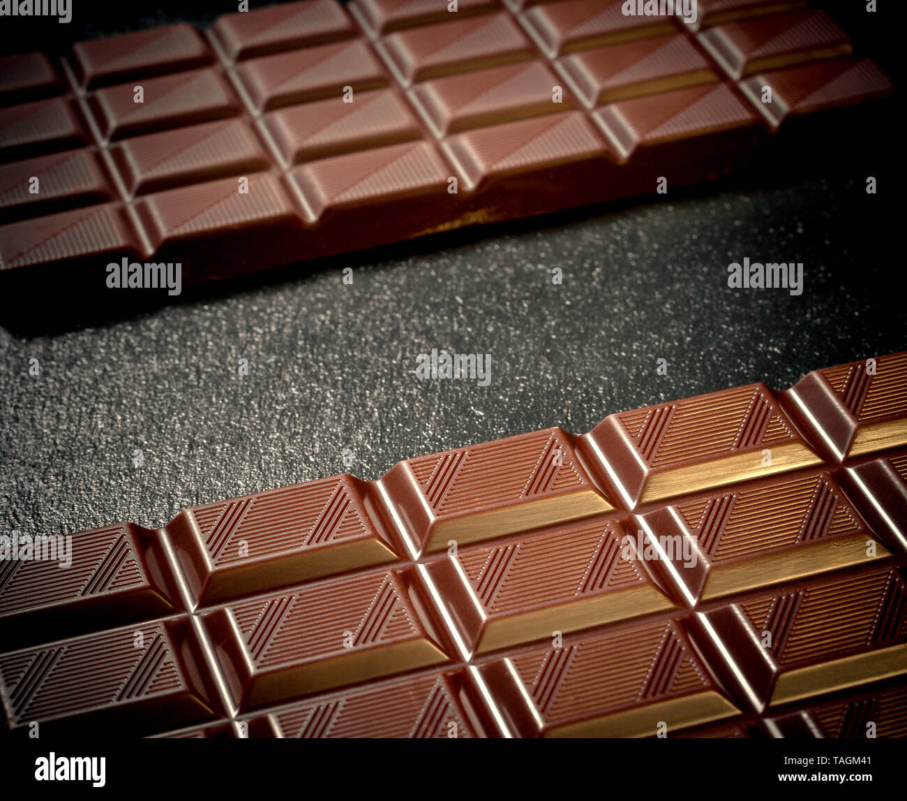 Two Black Chocolate Bars On Black Slate Plate Top View Stock