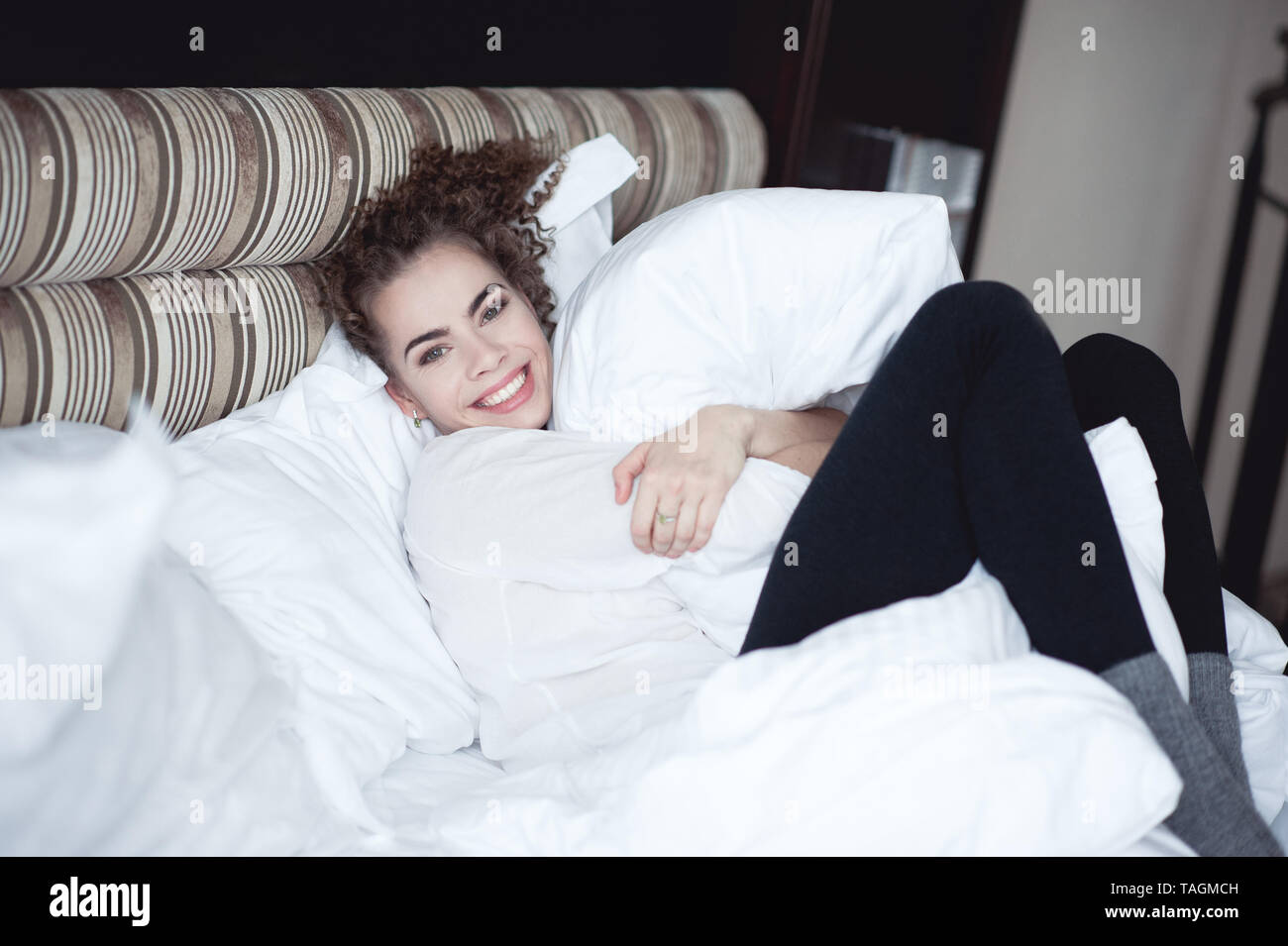 Smiling Woman 20 24 Year Old Lying In Bed Holding Pillow