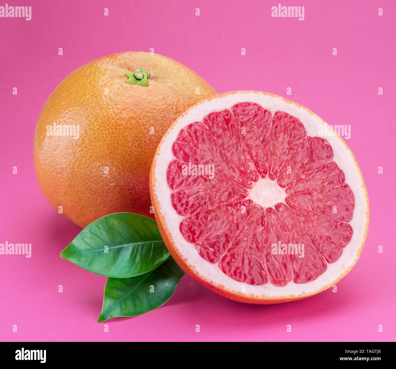 Grapefruit and grapefruit slice isolated on pink background. Stock Photo