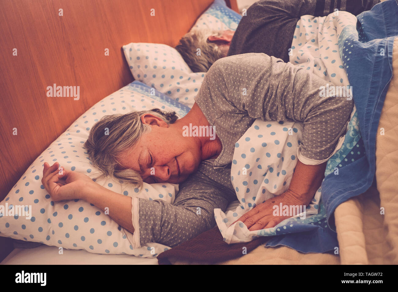 Caucasian people at home - old senior couple sleeping in the bedroom at the morning - retired lifestyle and real life moment - forever together concep Stock Photo
