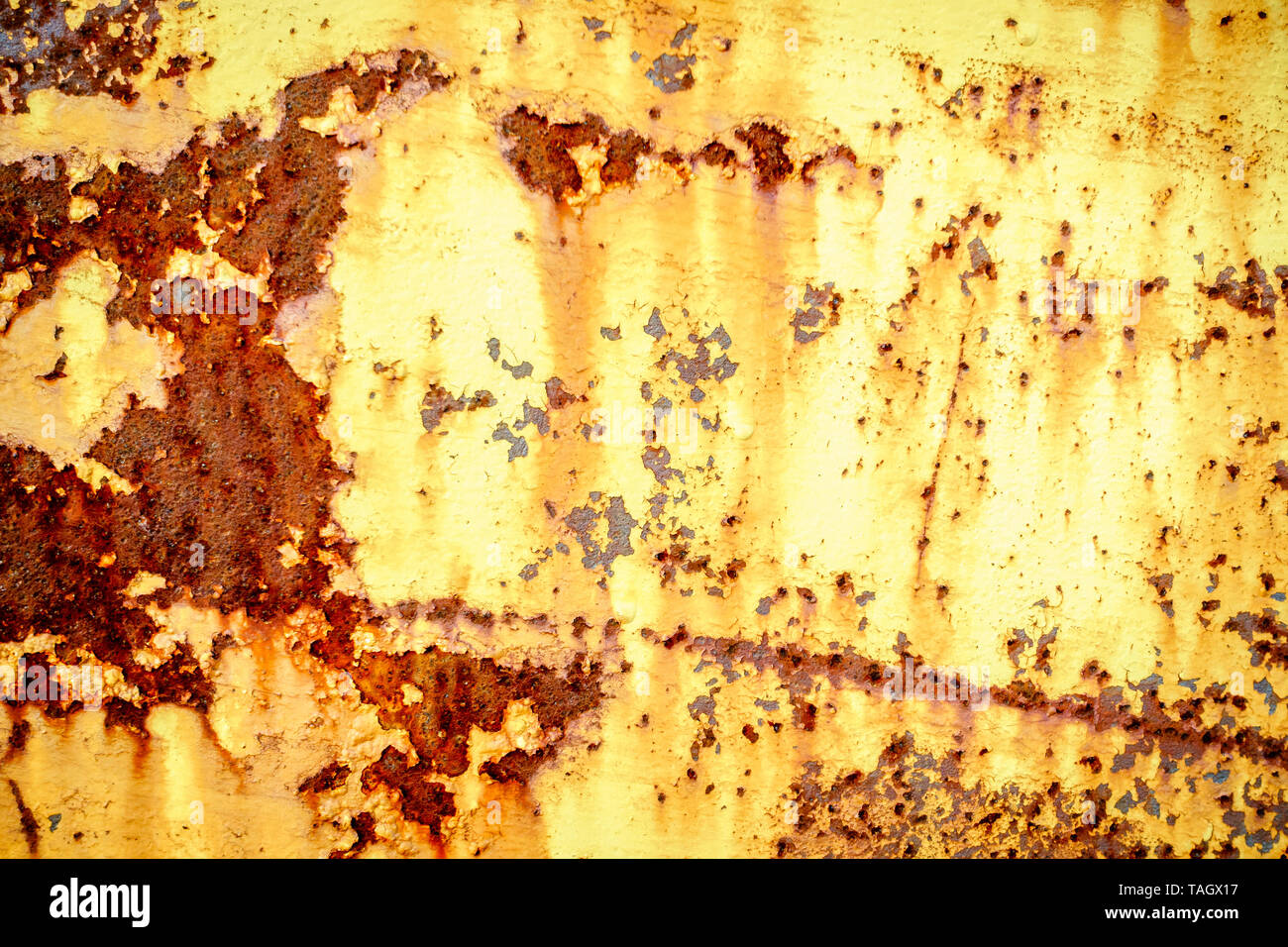 Close-up image of rusted metal surface with remnants of yellow paint Stock Photo
