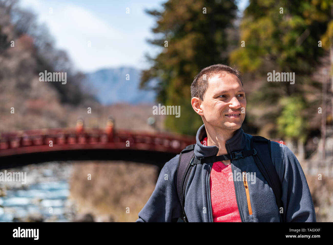 Nikko, Japan view on mountains and famous red bridge landmark in Tochigi prefecture in Japan with young happy tourist man Stock Photo
