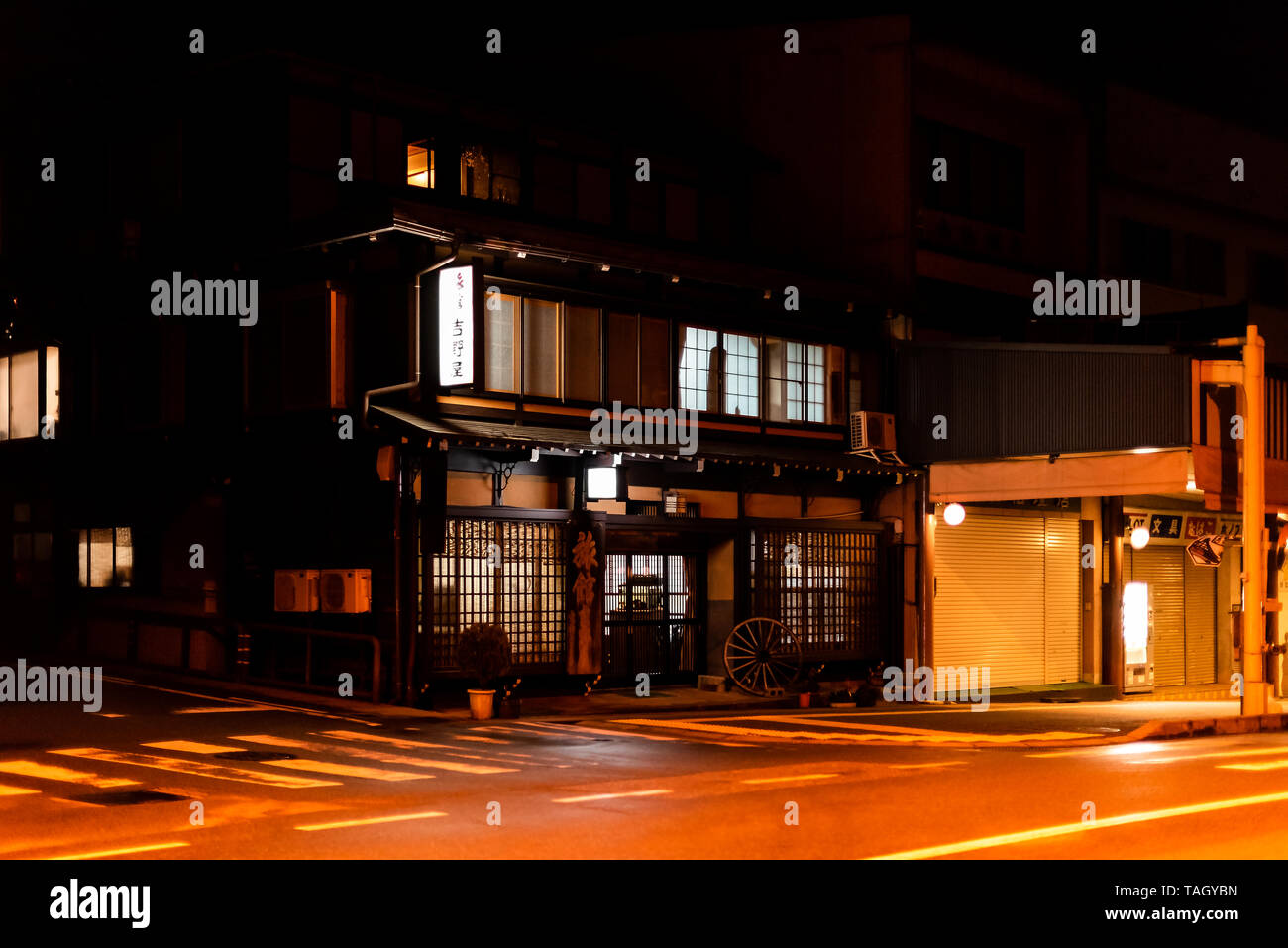 Takayama, Japan - April 8, 2019: Small town in Gifu prefecture in traditional village at night with illuminated lantern lamps and street road Stock Photo