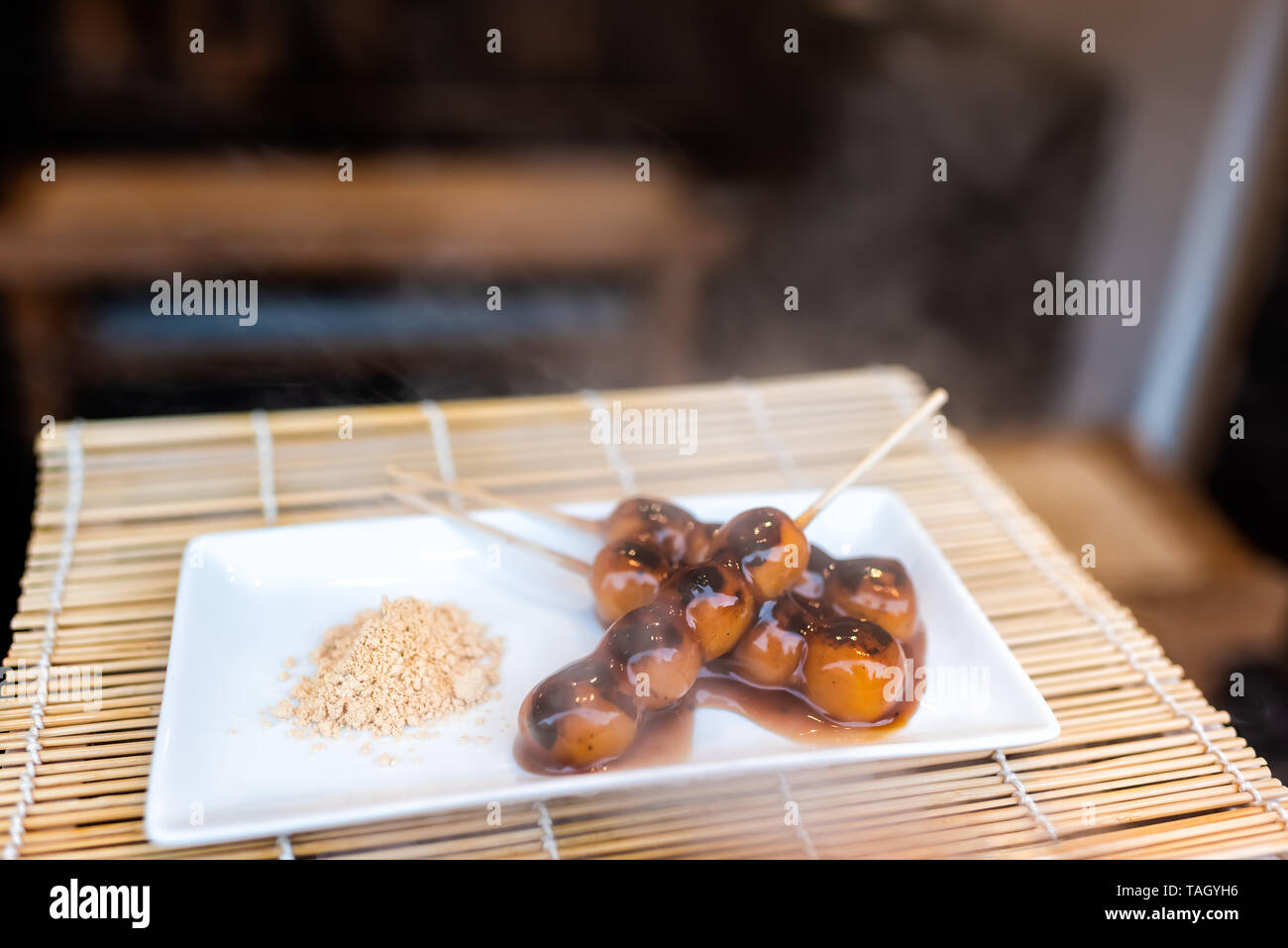 Display of steaming hot mochi dango snack with rice cake and miso soy sauce syrup on bamboo traditional Japanese street food Stock Photo