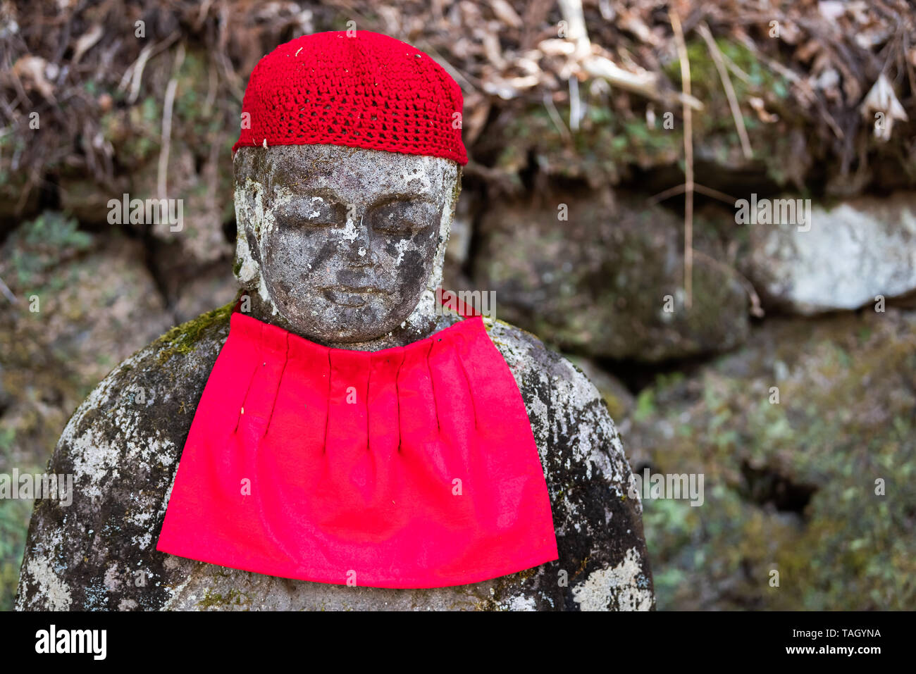 Famous red Jizo statue closeup in Kanmangafuchi Abyss, Nikko, Tochigi in Japan with bib