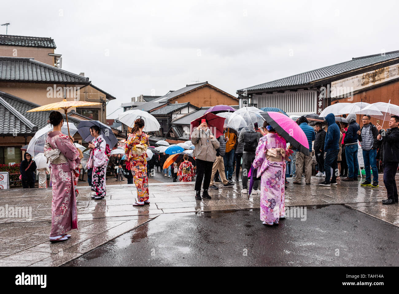 Visitors in kimono with umbrellas walking near Kiyomizu-dera Temple during rainy day in Kyoto, showing perfect indoor and covered areas for kimono photography and cultural experiences