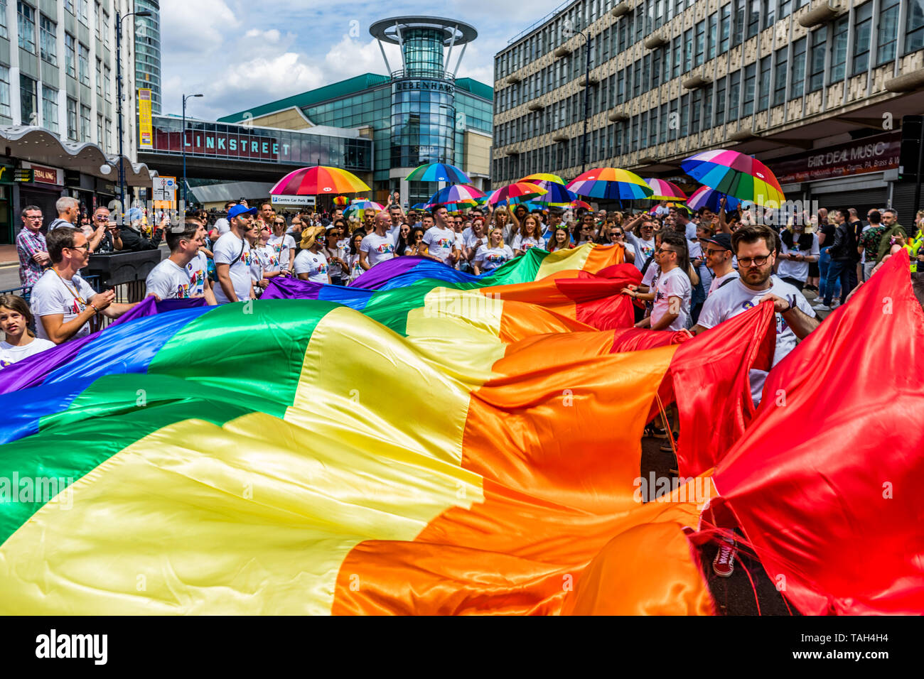Members of the LGBTQ community are seen holding a rainbow flag and umbrellas during the Birmingham Pride parade. Birmingham Pride this year is endorsing the controversial of No Outsiders educational programme, organisers are hopeful that this year’s event will be the biggest in its 22 year history, with the largest Muslim contingent ever seen at Birmingham Pride, an annual festival for the LGBTQ community usually takes place over the Spring Bank Holiday. The event begins with a parade from Victoria Square in the city centre to the Gay Village in Hurst Street. Stock Photo