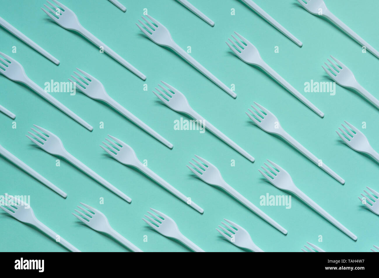 Plastic white forks on pastel blue background Stock Photo