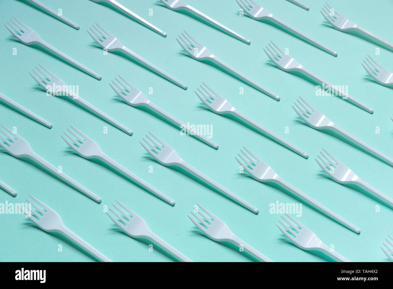 Plastic white forks on pastel blue background Stock Photo