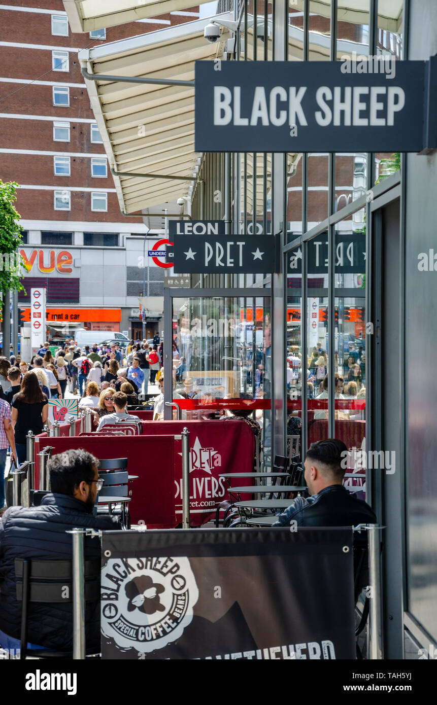 People sit outside a coffee shop in Shepherd's Bush, London, UK Stock Photo