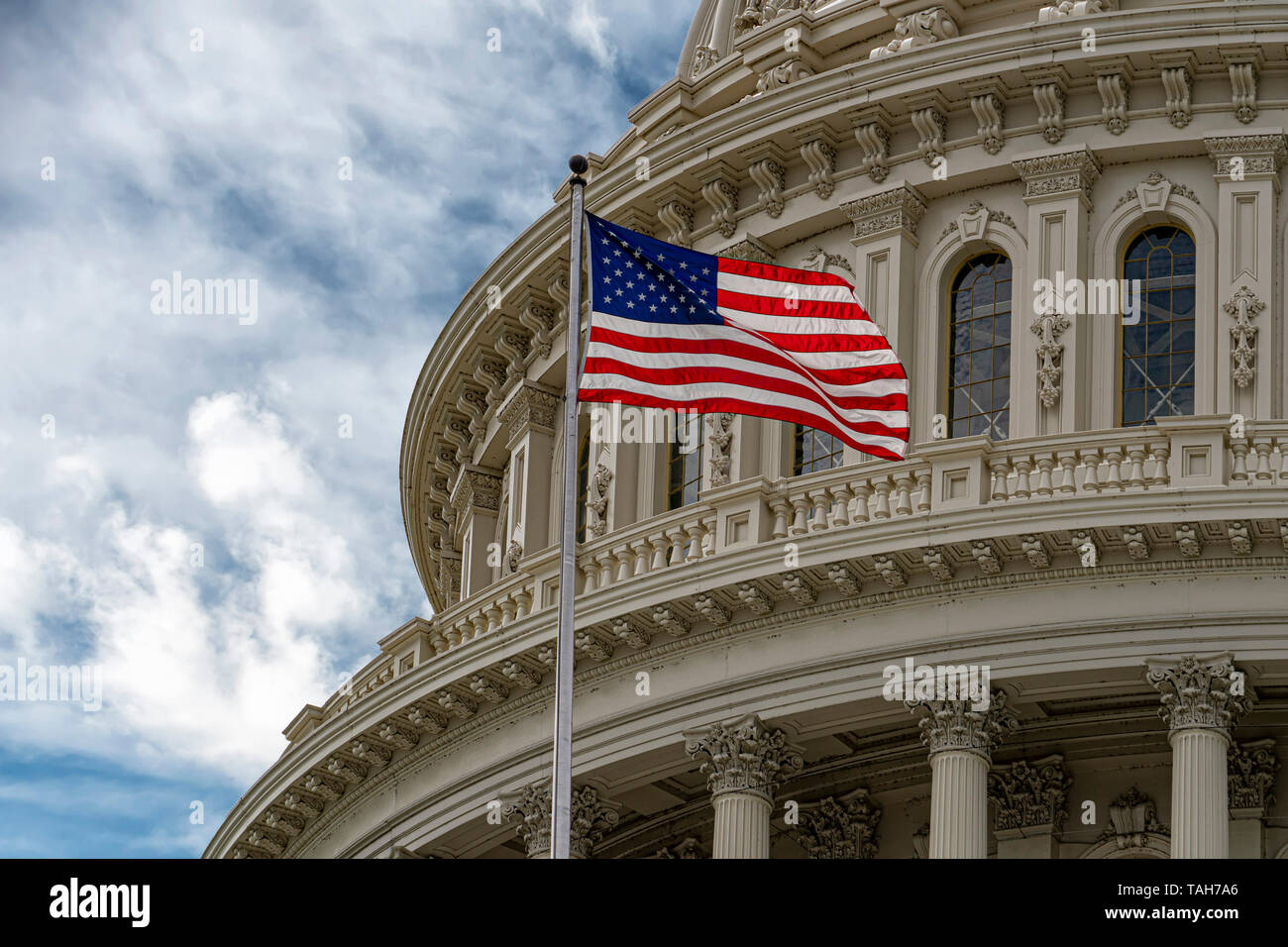 Washington DC Capitol with waving flag on cloudy day Stock Photo - Alamy