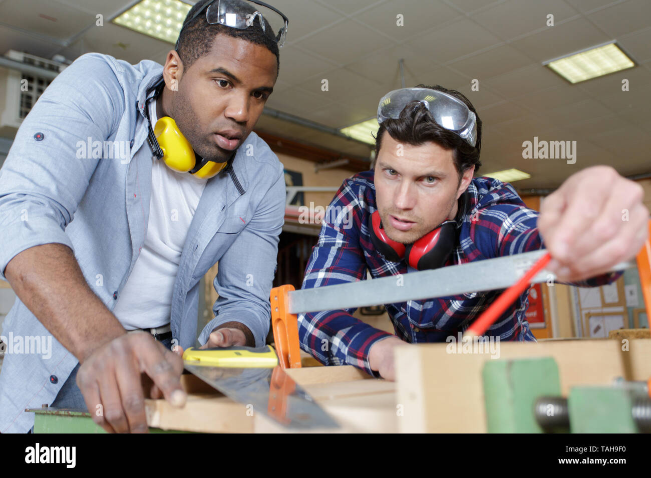 engineer teaching apprentices to use processing machines Stock Photo