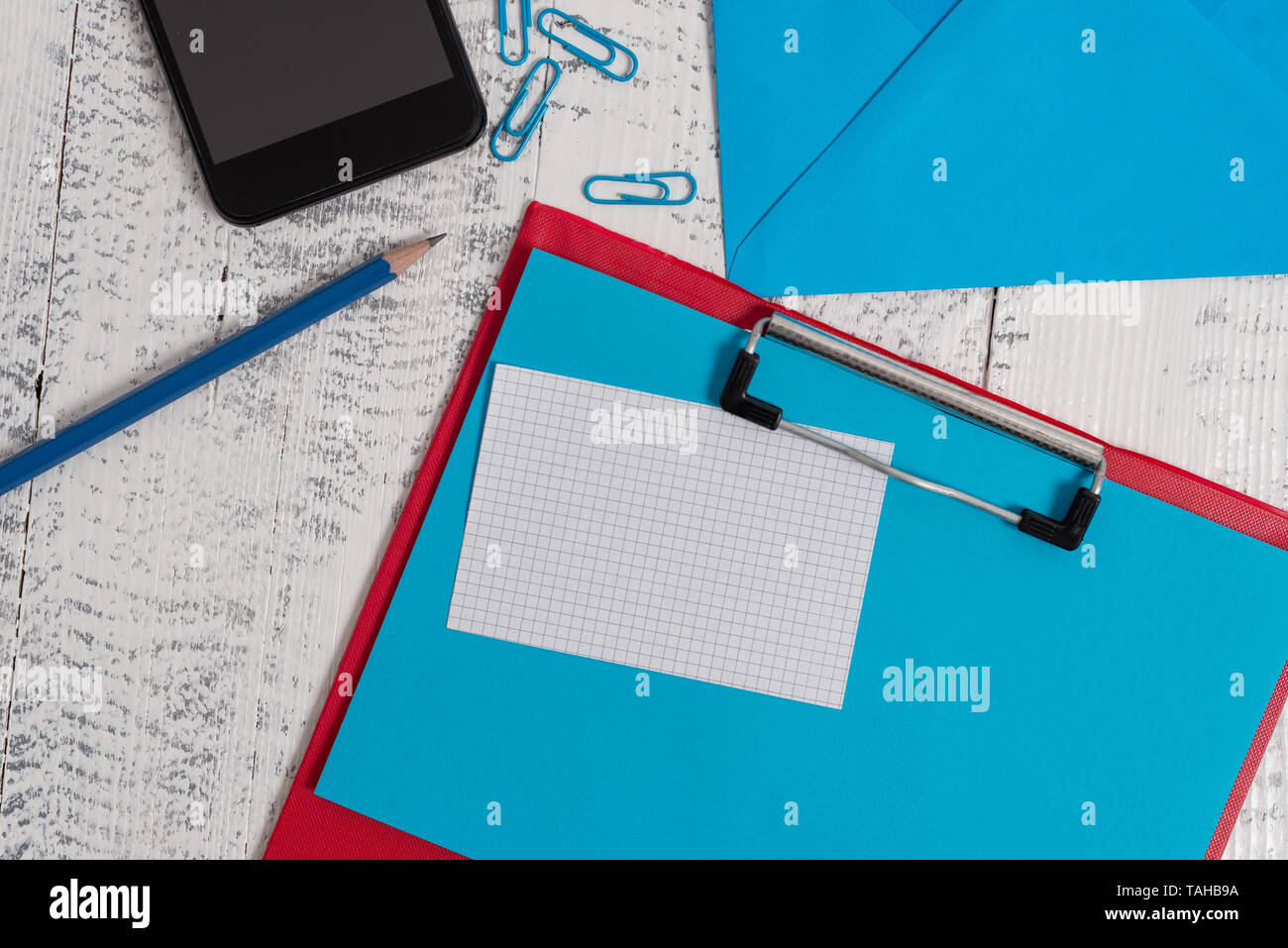 Clipboard sheet pencil note clips smartphone envelope wooden background Stock Photo