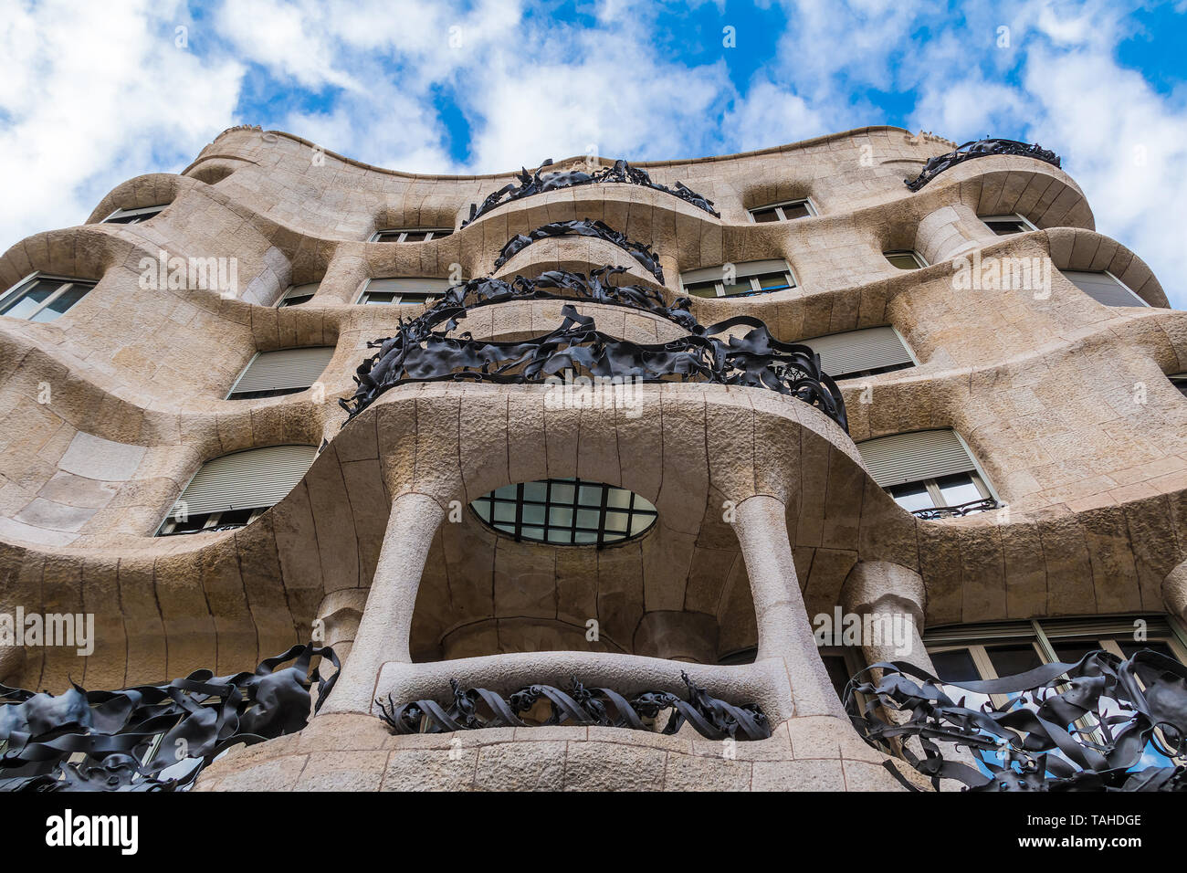 Barcelona, Catalonia, Spain - November 19, 2018: Worm's-eye view of Casa Mila on the background of cloudy sky. The building designed by Antonio Gaudi  Stock Photo