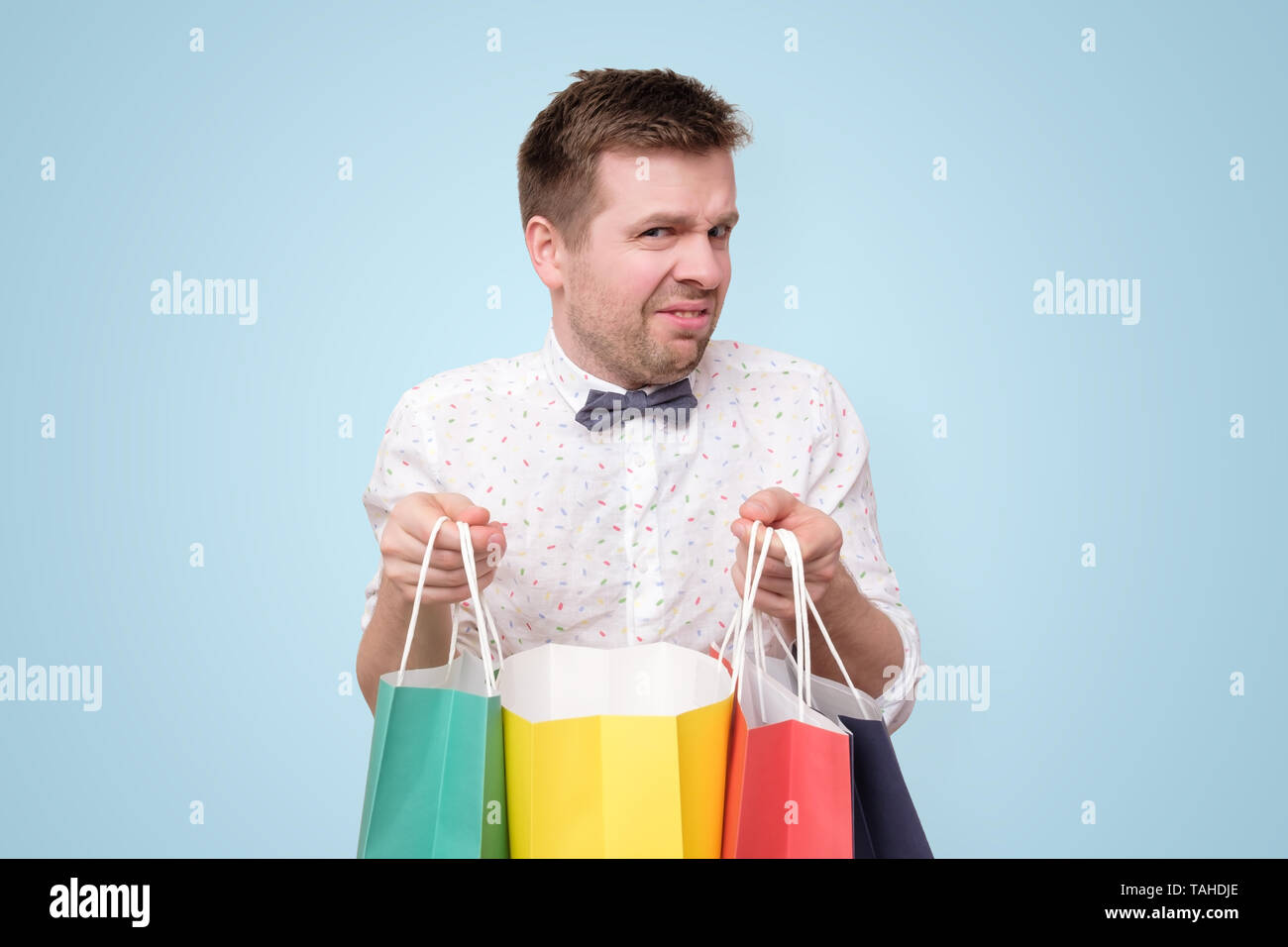 Young man holding colored paper packages with gifts. Stock Photo