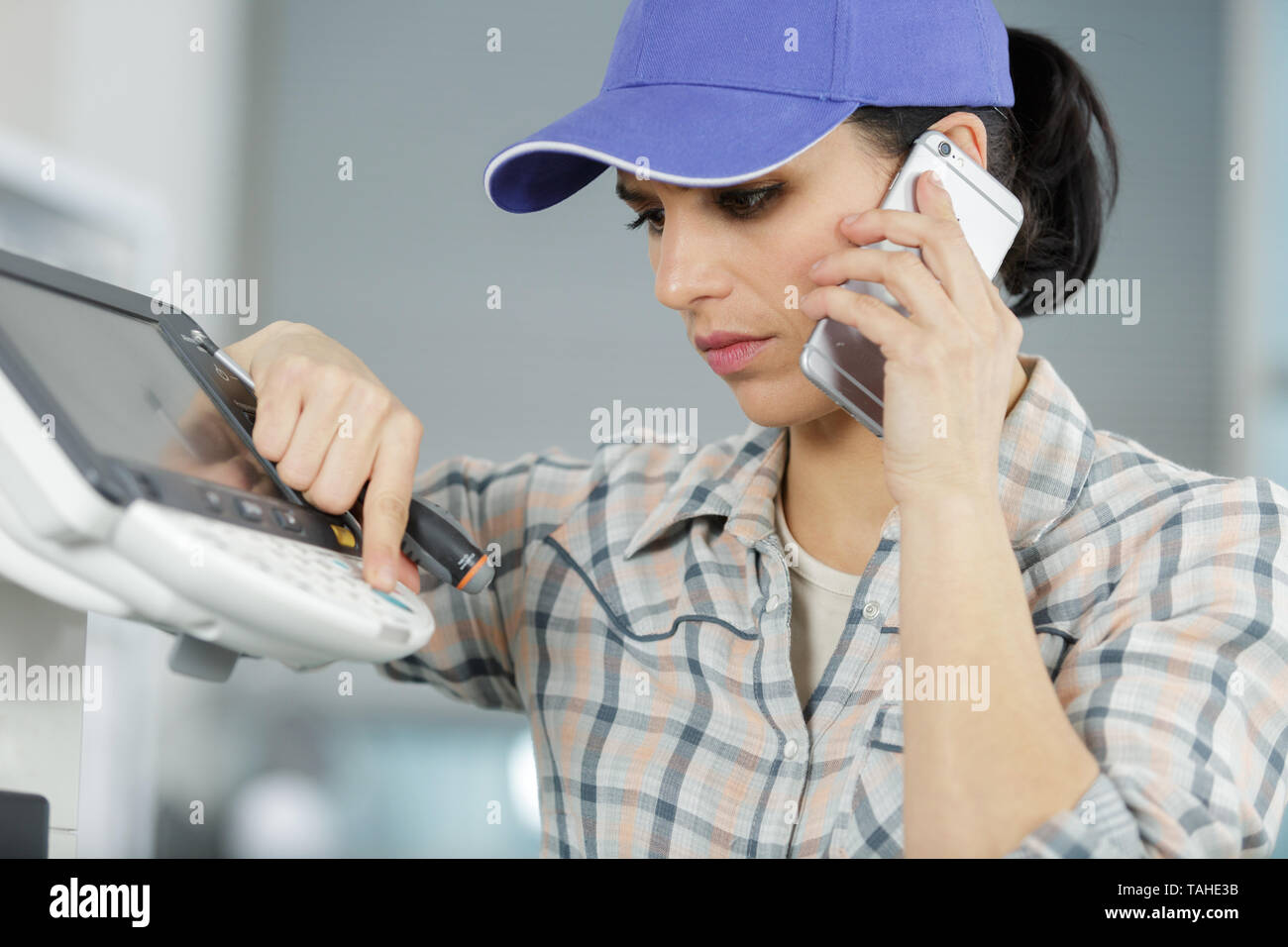 female repairer on the phone fixing printer Stock Photo