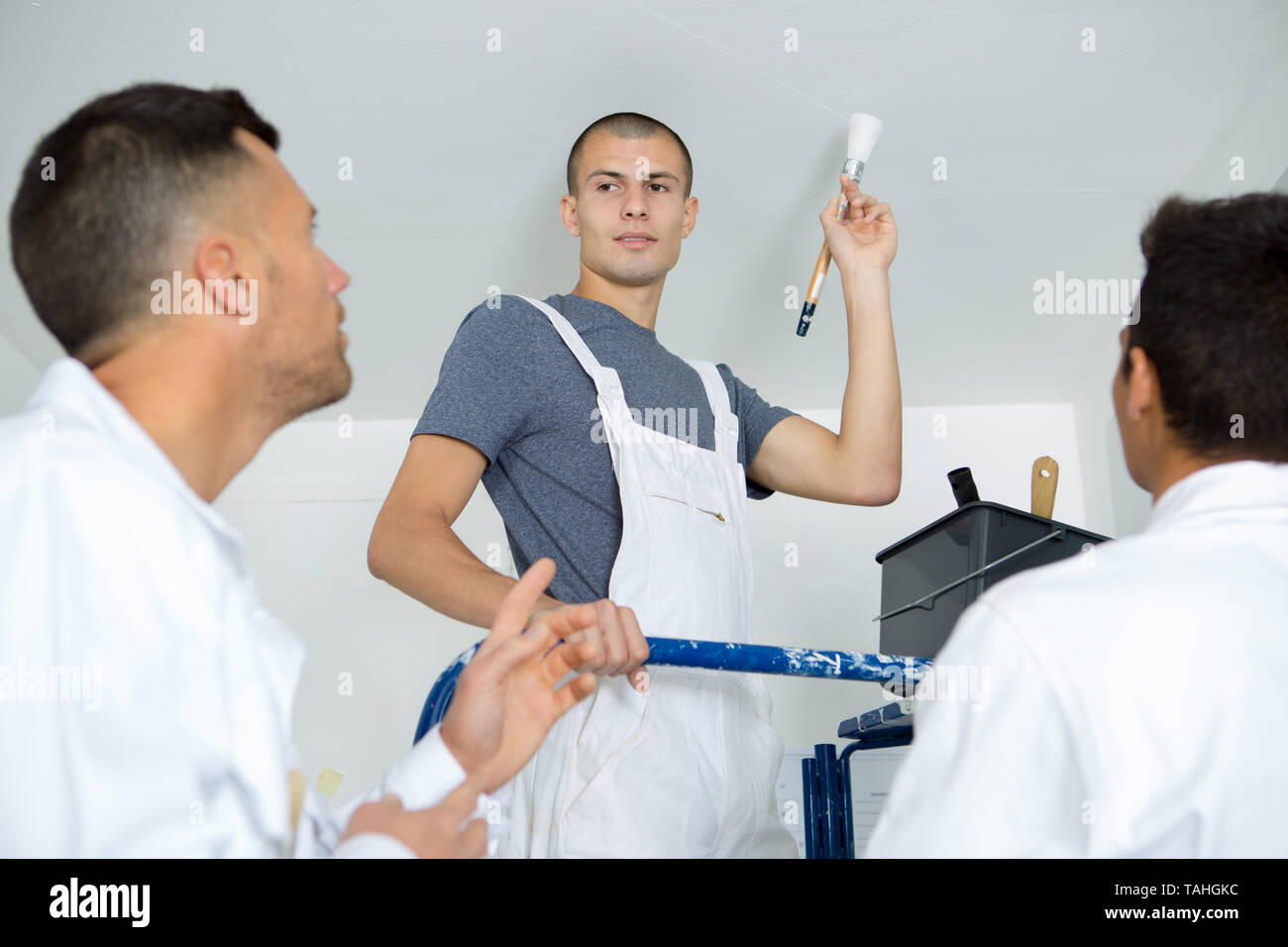 instructor showing apprentices how to paint Stock Photo