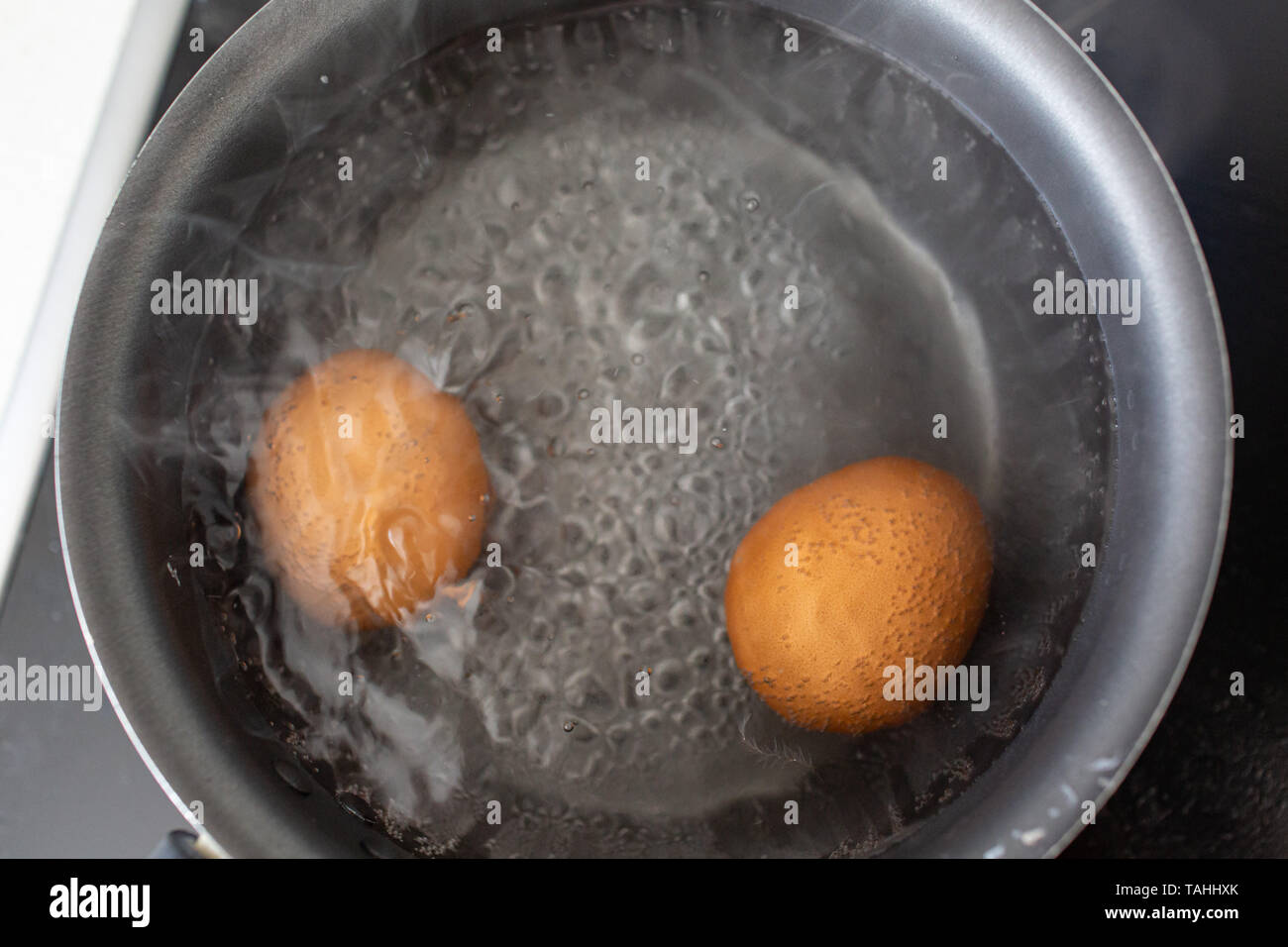 Eggs are boiled in a saucepan in boiling water. Stock Photo