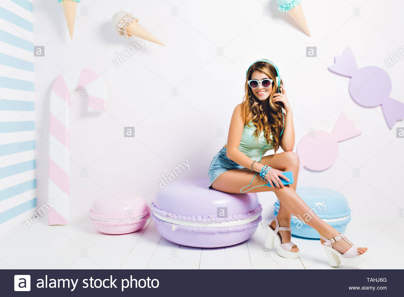 Beautiful Girl In Denim Shorts Resting On Cookie Pillow Playing