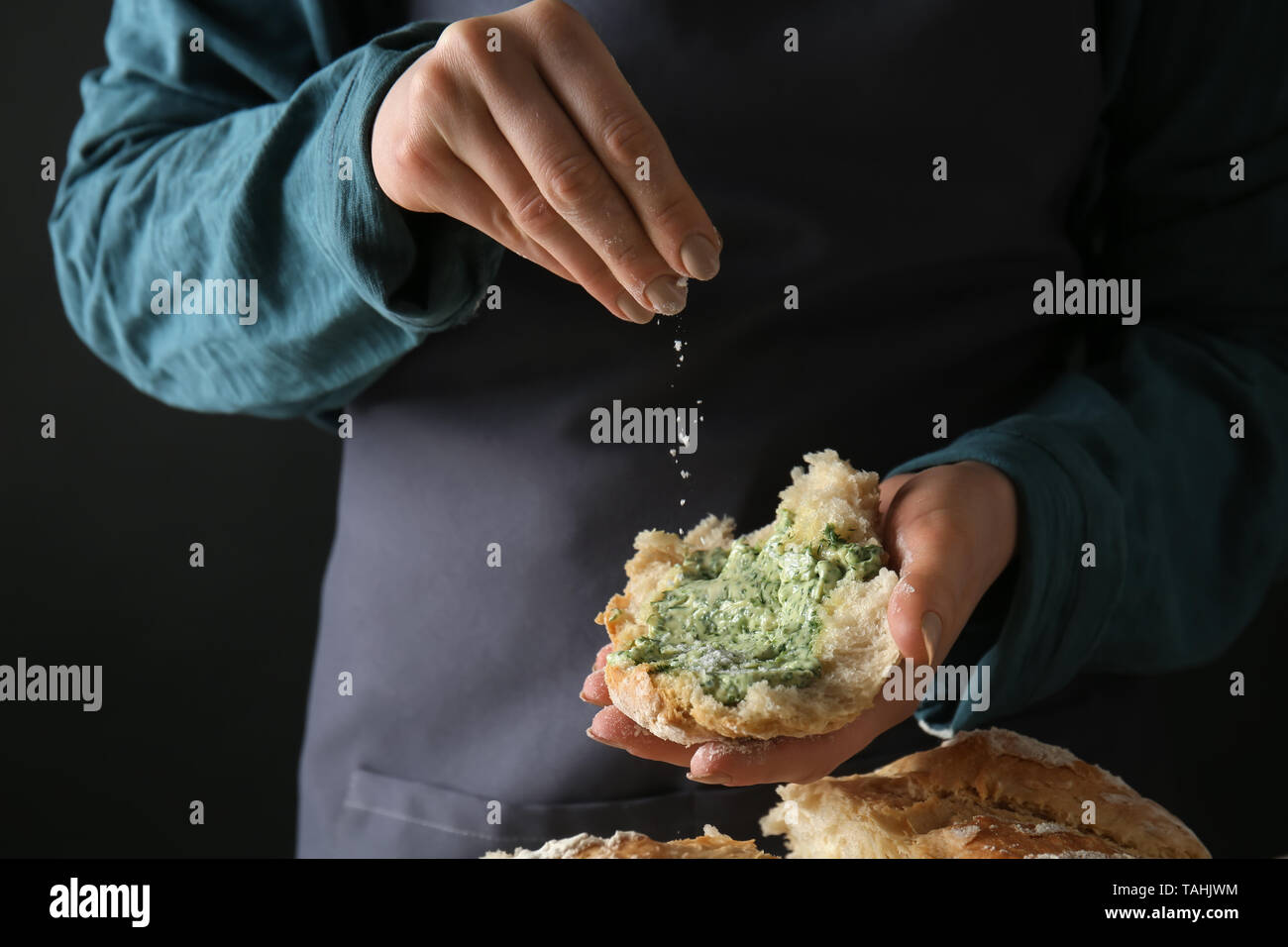 Young Woman Sprinkling Cheese Onto Piece Of Fresh Bread With Green Butter Against Dark Background Closeup Stock Photo Alamy